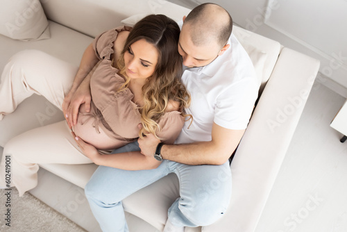 family concept. happiness concept. close-up portrait of a pregnant belly that embraces female and male hands. close-up portrait of embracing spouses. view from above