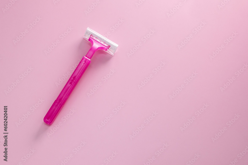 Disposable shaving razor for hair removal on pink background Disposable shaving razor for hair removal on pink background