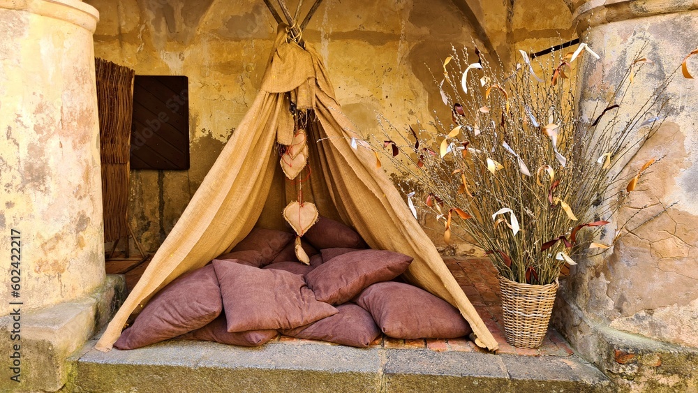Obraz premium An impromptu small hut with many pillows against stone wall