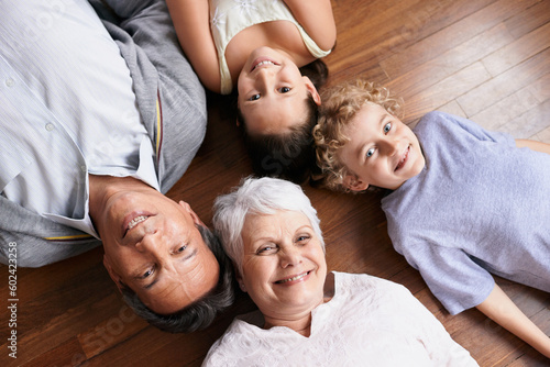 Portrait  floor or top view of grandparents with happy kids smiling together in family home or retirement. Senior grandma  relax or fun children siblings bonding to enjoy quality time with old man