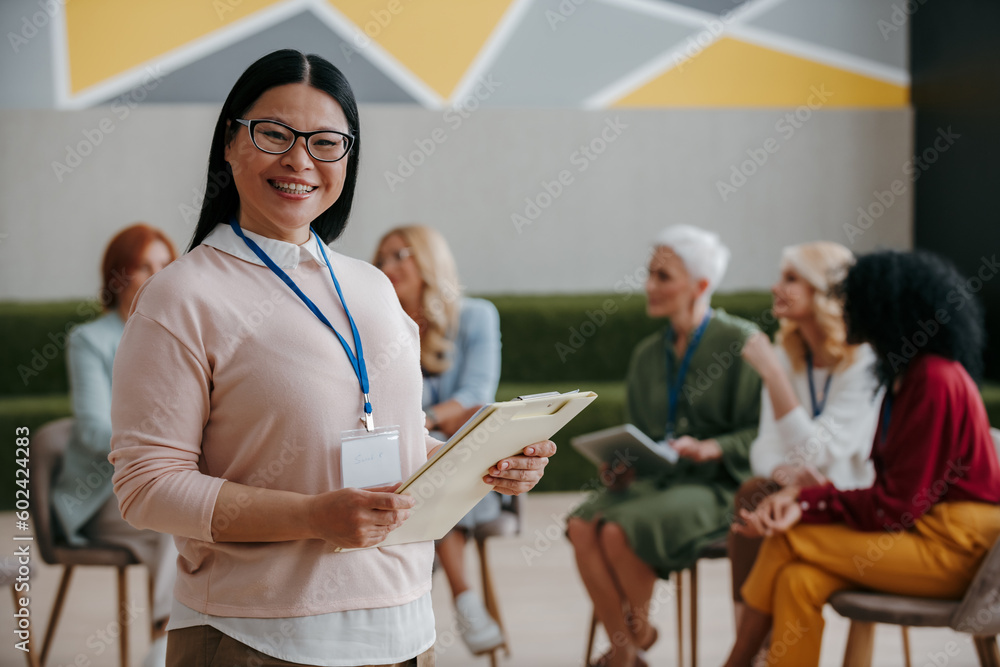 Fototapeta premium Happy Asian woman looking at camera while visiting group training class for females