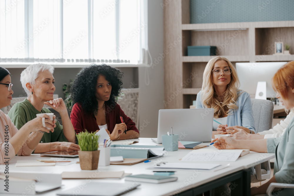 Group of mature women discussing business while having meeting in the office together Group of mature women discussing business while having meeting in the office together