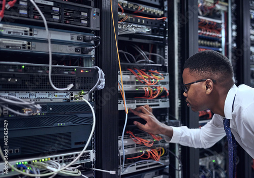 Black man, IT technician and server room for cyber security, data or network storage inspection. African male person or networking administrator checking system, cables or installation at datacenter