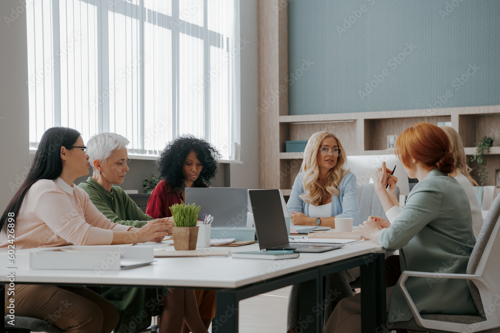Group of confident mature women having business meeting in the office Group of confident mature women having business meeting in the office