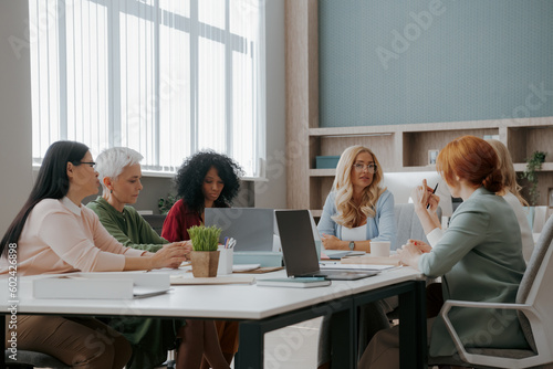 Group of confident mature women having business meeting in the office © gstockstudio
