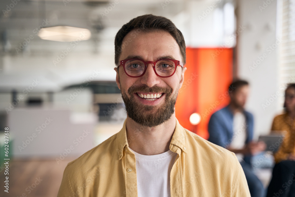 Obraz premium Portrait of confident smiling businessman, middle aged freelancer wearing stylish red eyeglasses standing in office. Happy smart student looking at camera in university campus, education concept