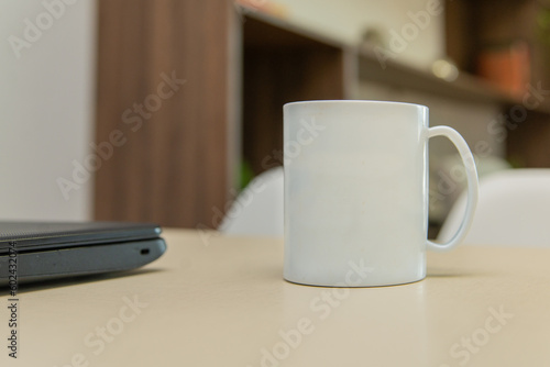 Caneca / xícara branca em mesa de escritório photo