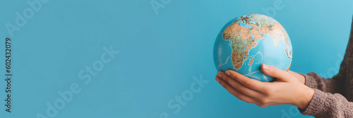 Earth Day. The globe lies in woman's hands on a light blue background. Environmental protection concept. AI Generative. Wide banner with copy space. 