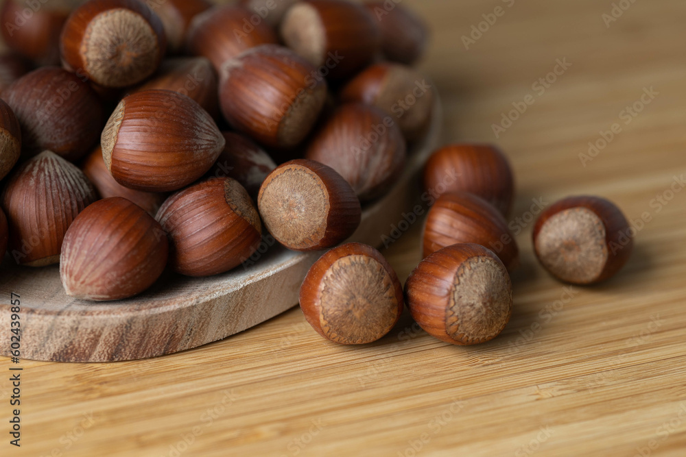 handful of hazelnuts on wooden bowl and wooden table, very healthy nuts handful of hazelnuts on wooden bowl and wooden table, very healthy nuts
