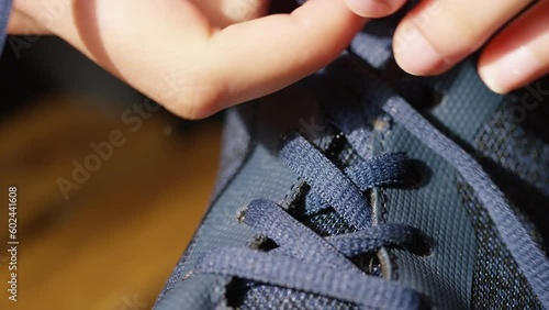 Front view close up of hands tying up laces on a pair of sneakers