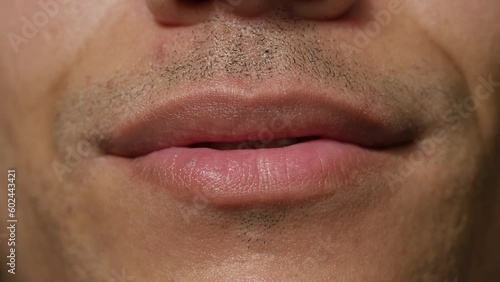 Close up of male mouth licking lips to camera and biting bottom lip suggestively photo