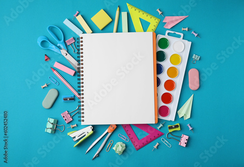 Different school stationery items and notebook on light blue background, flat lay with space for text. Back to school