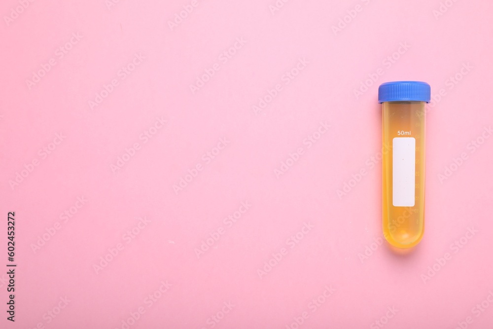 Test tube with liquid on pink background, top view and space for text. Kids chemical experiment toy Test tube with liquid on pink background, top view and space for text. Kids chemical experiment toy