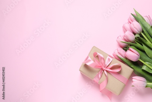 Beautiful gift box and bouquet of tulip flowers on pink background, flat lay. Space for text © New Africa