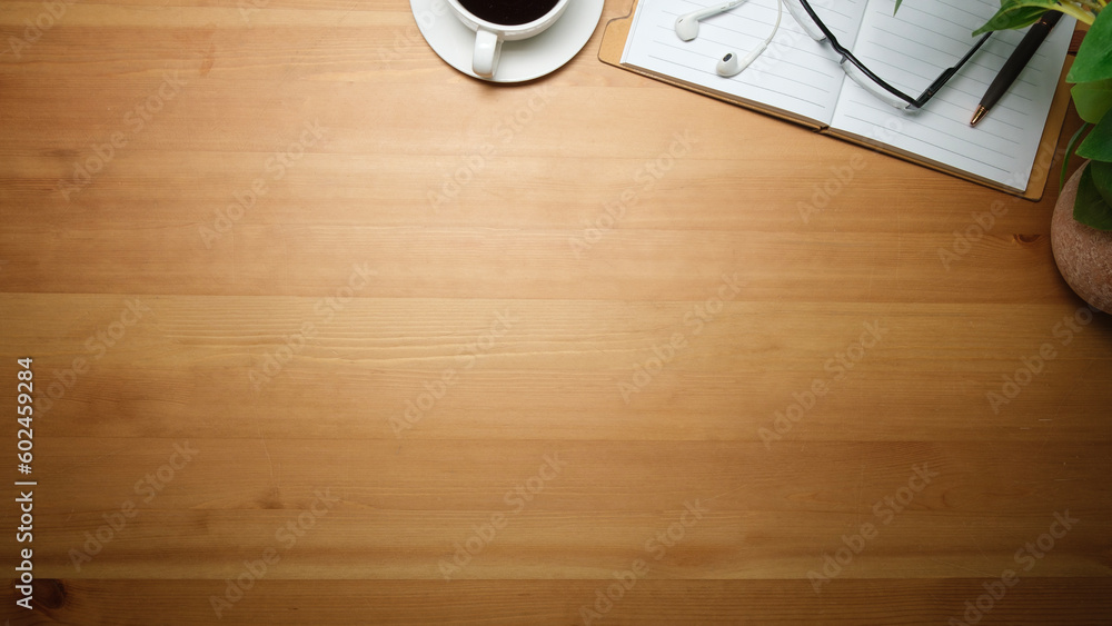 Simple workplace with cup of coffee, glasses, notebook and potted plant on wooden table. Top view with copy space. Simple workplace with cup of coffee, glasses, notebook and potted plant on wooden table. Top view with copy space.