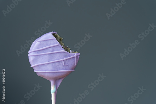 Colorful homemade cake pop with bite taken out of it.