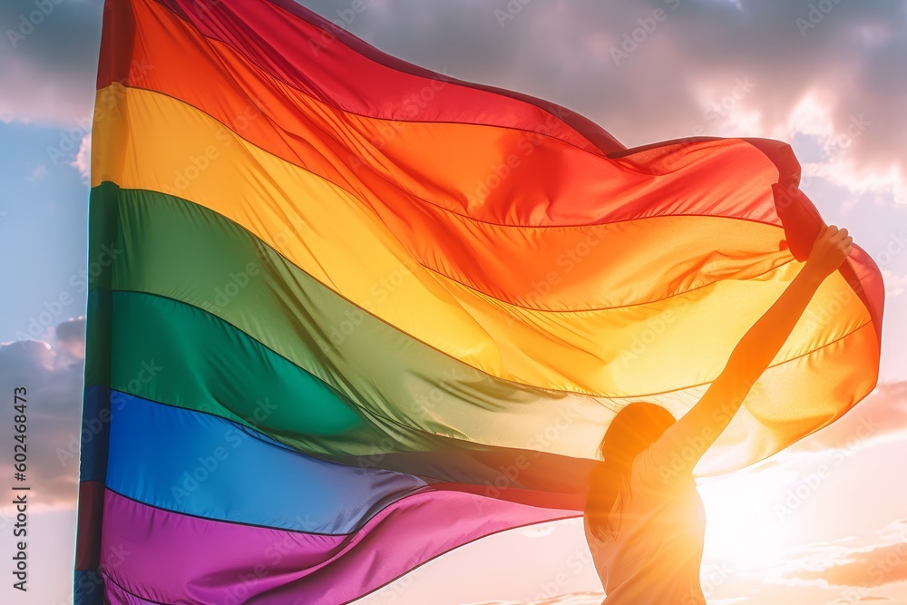 Pride rainbow lgbt gay flag being waved by woman back view in the ...