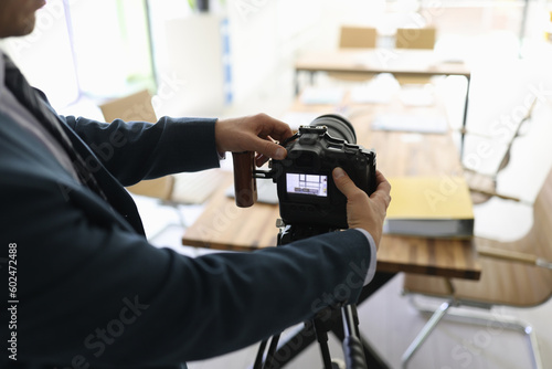 Successful businessman in suit sets up professional camera