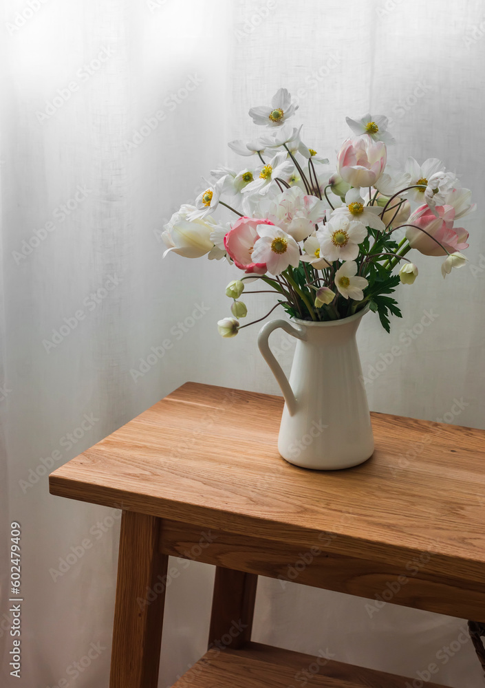 Bouquet of summer flowers in an enameled jug on an oak bench Bouquet of summer flowers in an enameled jug on an oak bench