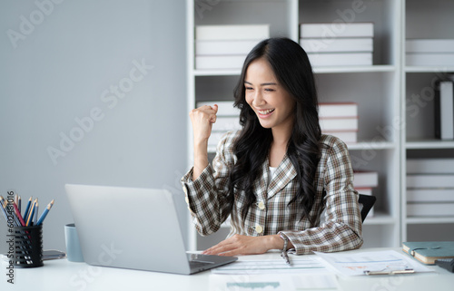 Successful business woman do winner gesture in the office room, celebrating the good news.