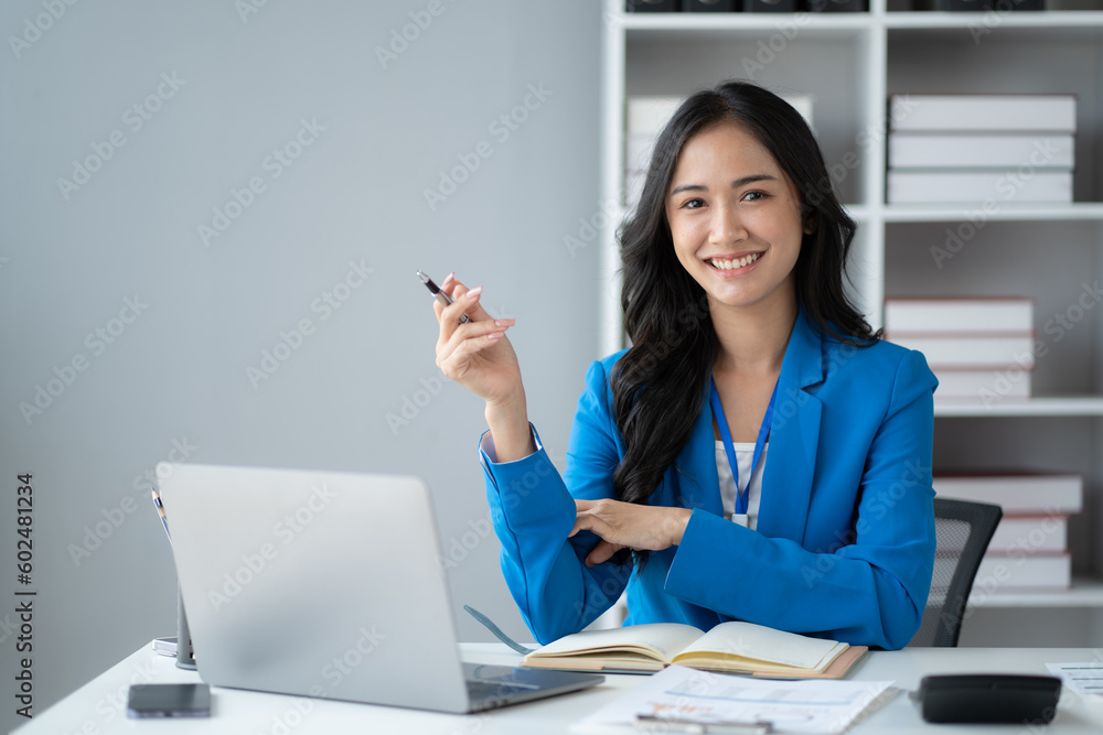 Young and pretty businesswoman sitting at her office desk, working on her project with laptop computer with positive energy. Young and pretty businesswoman sitting at her office desk, working on her project with laptop computer with positive energy.