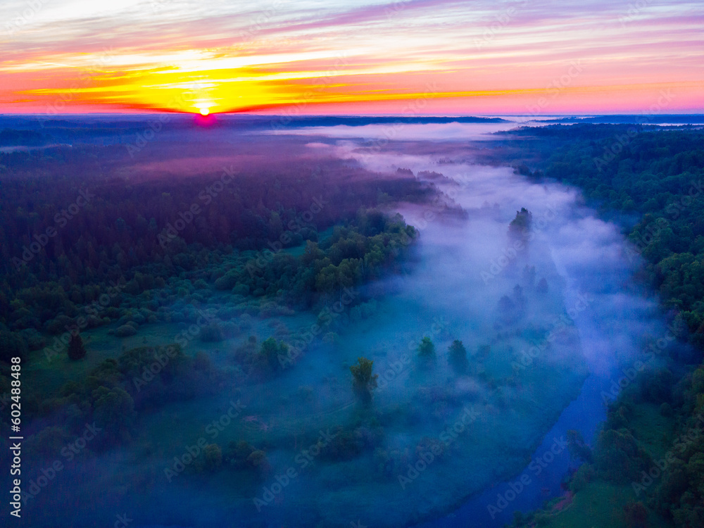 Drone's Eye View: Serene Sunrise Over Misty River and Woodland Landscape in Northern Europe Drone's Eye View: Serene Sunrise Over Misty River and Woodland Landscape in Northern Europe