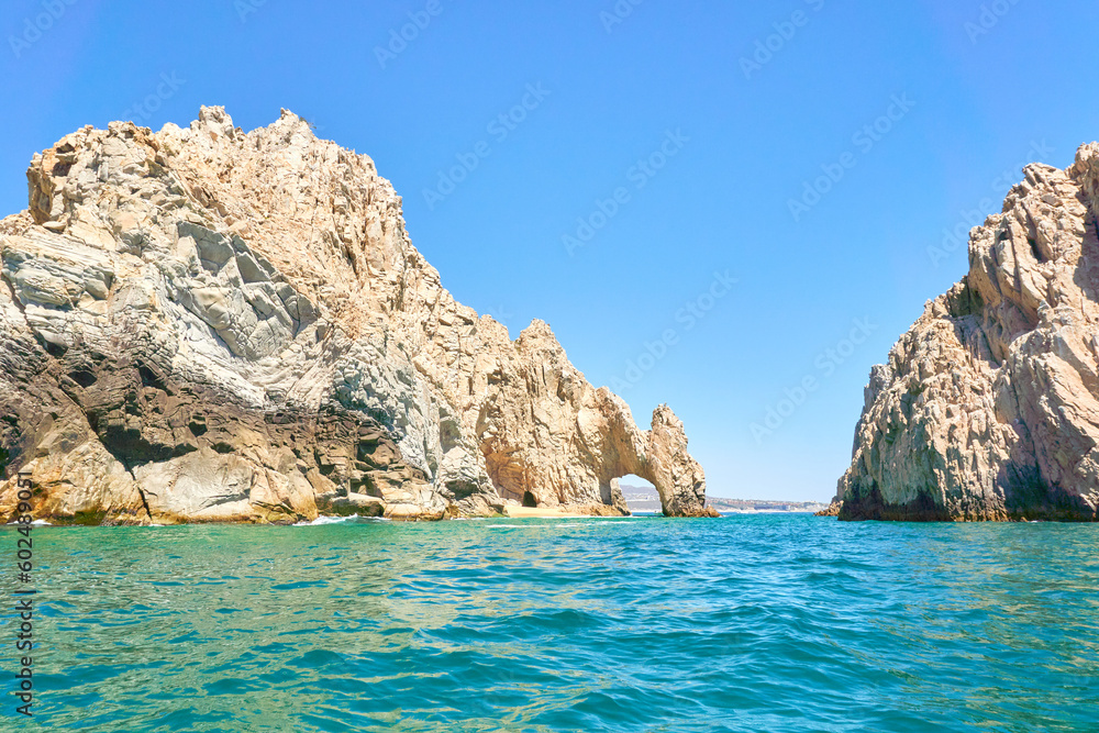 rocky mountains of los cabos, baja california sur, Mexico. Deep blue and emerald green Pacific Ocean in foreground. Los Cabos city in background.
