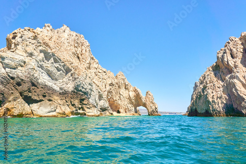 rocky mountains of los cabos  baja california sur  Mexico. Deep blue and emerald green Pacific Ocean in foreground. Los Cabos city in background.