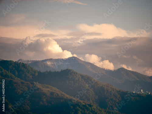 Green Mountains covered with trees nature landscape and clouds at sunset.