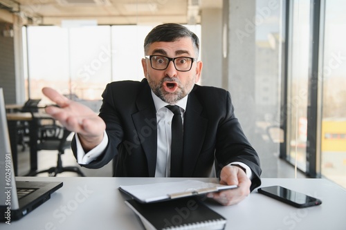 Angry businessman with document shouting at somebody