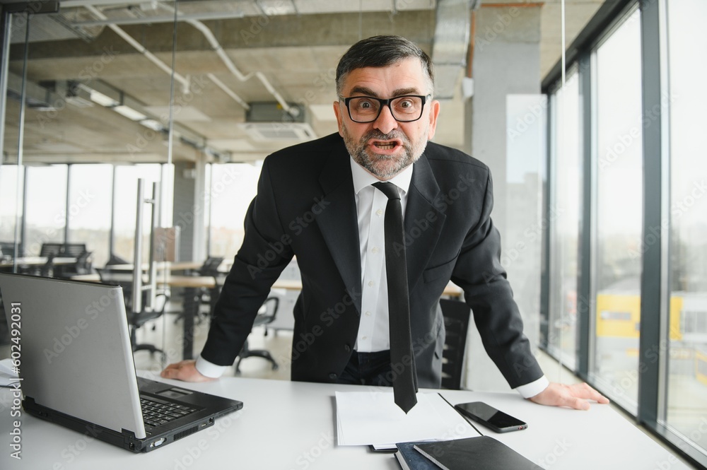 Angry businessman sitting at the table and screaming over. Angry businessman sitting at the table and screaming over.