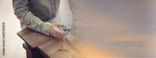 Order a gift. A man with a gift in his hand sits in front of the monitor screen.