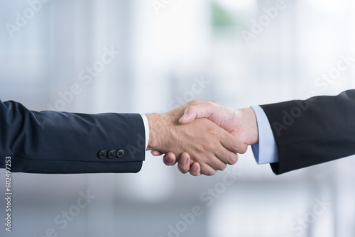 Image of a successful business transaction or business meeting Close-up of hands of two men in suits smiling and shaking hands No face