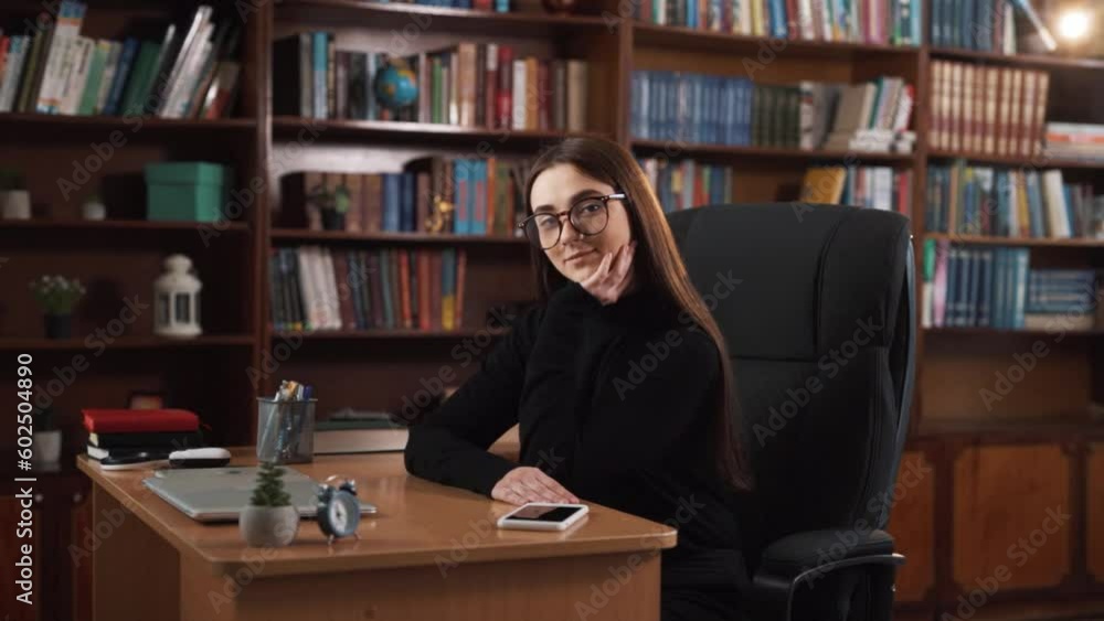 The girl is seated at her work table, appearing lost in thought. She is straightening her hair, and from her emotions, it can be inferred that she is feeling content, joyful, and smiling. The girl is seated at her work table, appearing lost in thought. She is straightening her hair, and from her emotions, it can be inferred that she is feeling content, joyful, and smiling.