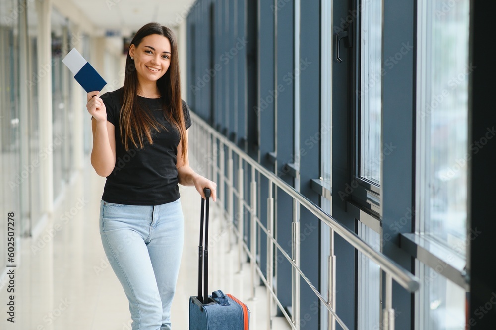 Vacation Travel. Beautiful Young Brunette Lady In Airport Terminal, Happy Smiling Millennial Lady Ready For Holiday Trip, Going To Departure Gate, Copy Space.