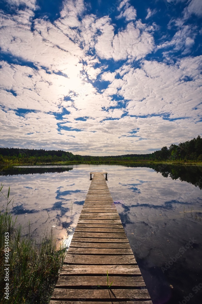 Obraz premium Beautiful summer afternoon landscape by the lake. Charming wooden pier over a small lake in Michala Gora, Poland.
