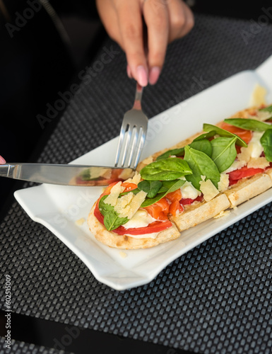 Open sandwich, toast with salmon, cream cheese, tomato slices on white concrete table. Morning healthy breakfast with fish and cup of drink, side view, close up, macro