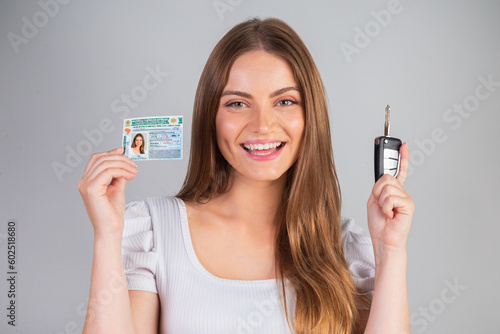 Blonde Brazilian woman holding motor vehicle driver's license and car key. Translation in English (national driver's license)