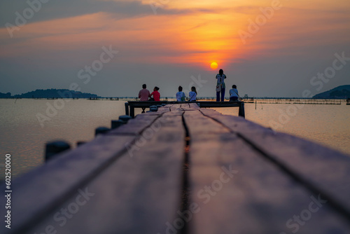 couple walking on the pier at sunset