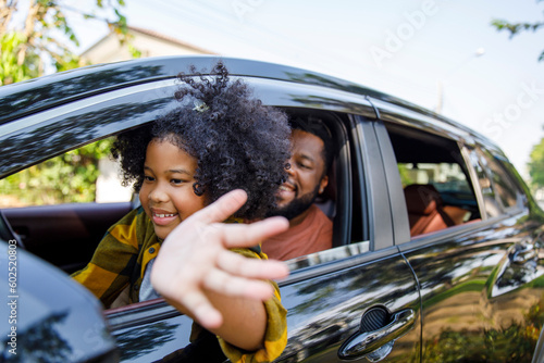 Smiling daughter enjoying road trip with father in car photo
