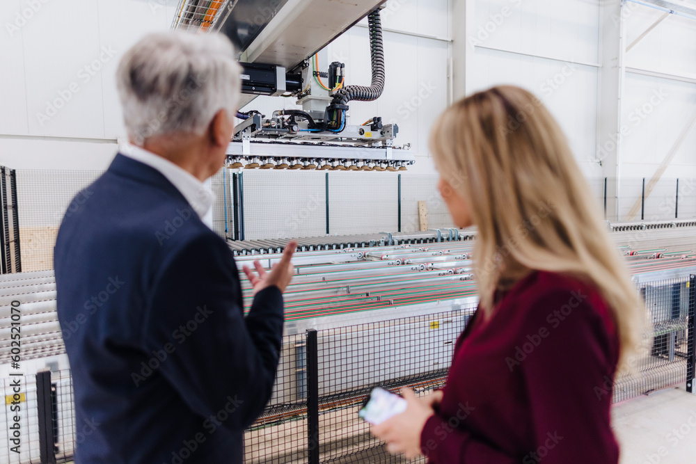 Senior businessman explaining colleague in factory Senior businessman explaining colleague in factory