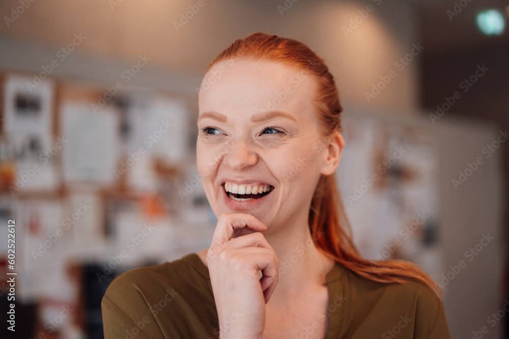 Happy redhead woman with hand on chin Happy redhead woman with hand on chin