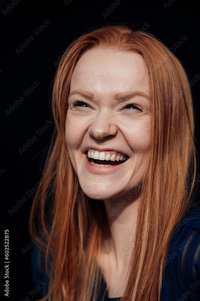 Happy woman laughing against black background Happy woman laughing against black background