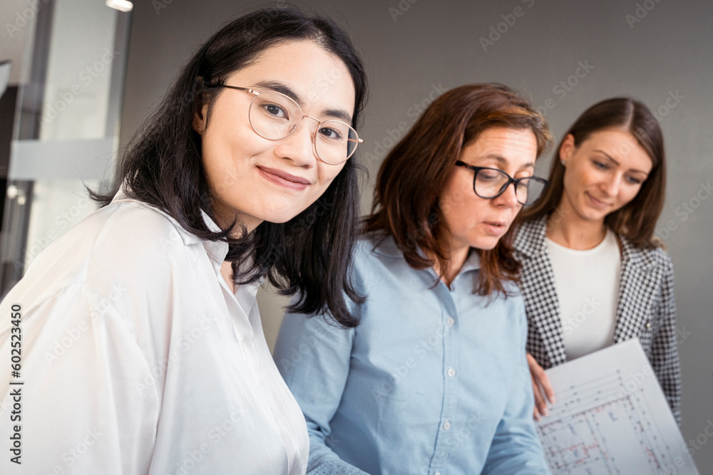 Smiling businesswoman working with colleagues on an architectural project Smiling businesswoman working with colleagues on an architectural project