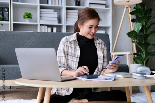 Asian women using calculator and mobile phone, Business accounting, budget and loan paper. work from home concept.