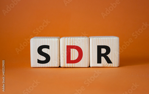 SDR, Special Drawing Rights. Wooden cubes with word SDR. Beautiful orange background. Business and SDR concept. Copy space. photo