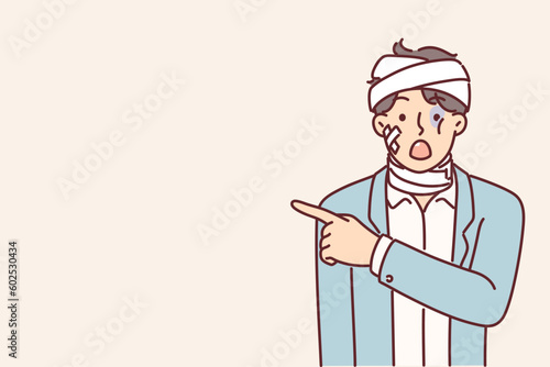Man with bandages and plaster points finger at copy space after getting into car accident