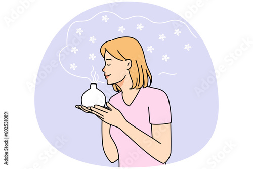 Young woman smell fragrance from aromatherapy diffuser