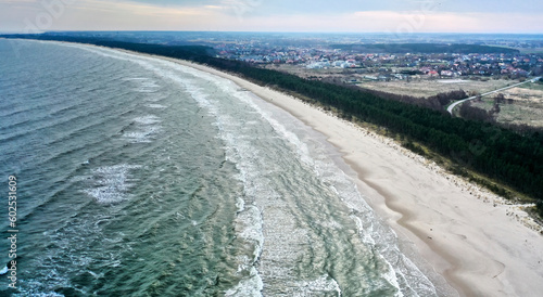 Aerial view with a Polish village behind the forest on the Baltic Sea in Poland