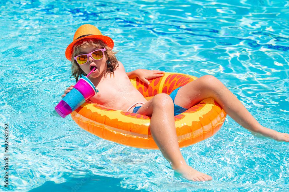 Kid boy swimming in pool play with floating ring. Smiling cute kid in sunglasses swim with inflatable rings in pool in summer day.
